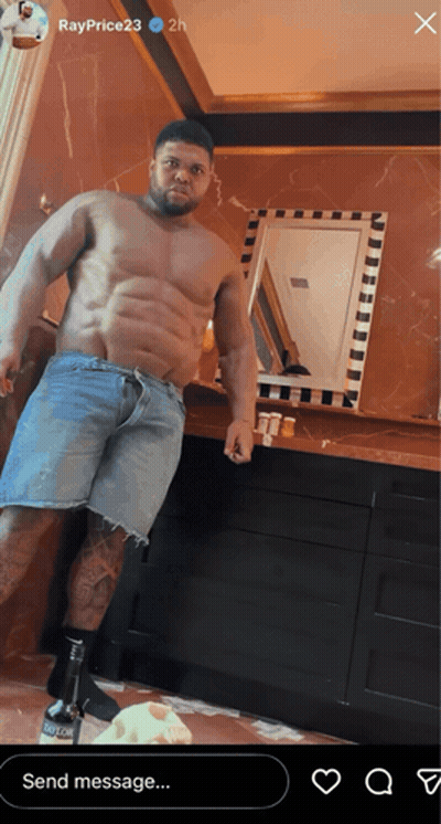 A Shirtless Man In Denim Shorts Is Standing In Front Of A Mirror In A Bathroom GIF