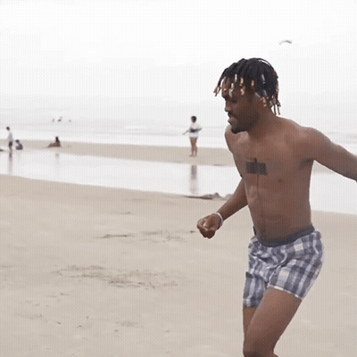 A Shirtless Man In Plaid Shorts Has A Tattoo On His Chest GIF