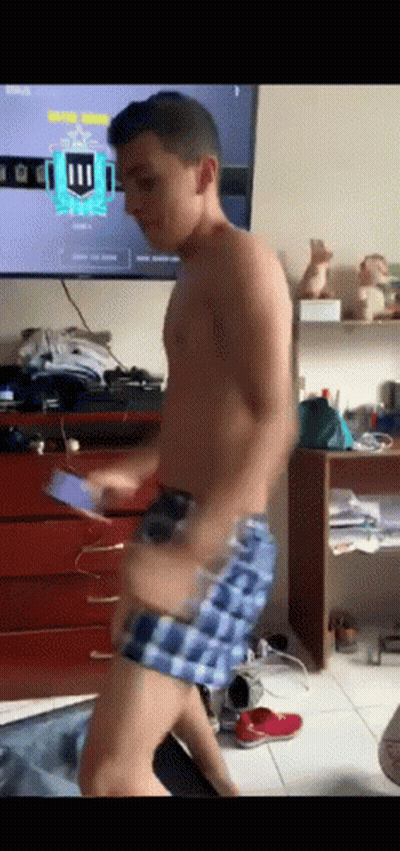 A Shirtless Man In Plaid Shorts Is Dancing In Front Of A Television With The Number 11 On It GIF