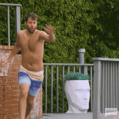 A Shirtless Man In Swim Trunks Is Running On A Deck With A Bravo Logo In The Background GIF