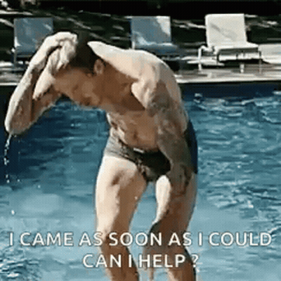 A Shirtless Man In Swim Trunks Is Standing In A Pool . GIF