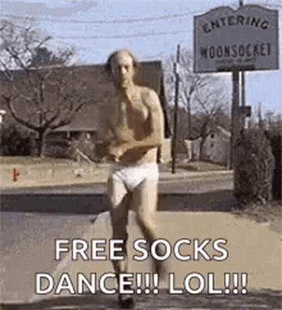 A Shirtless Man In Underwear Is Running Down A Street In Front Of A Sign That Says Free Socks Dance Lol . GIF