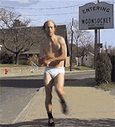 A Shirtless Man In White Underwear Is Running In Front Of A Sign That Says Entering Moonsocke GIF