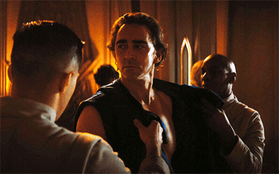 A Shirtless Man Is Being Helped By Another Man GIF