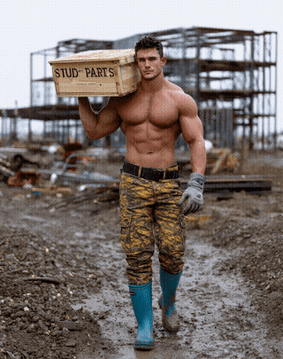 A Shirtless Man Is Carrying A Box Of Stud Parts GIF