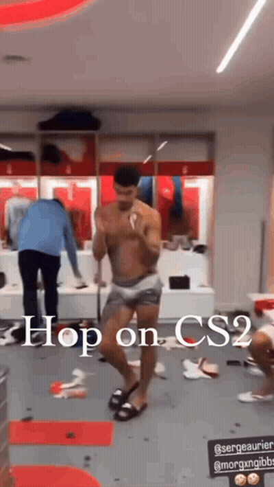 a shirtless man is dancing in a locker room with the words `` hop on cs2 '' written above him .