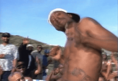 A Shirtless Man Is Dancing In Front Of A Crowd Of People GIF