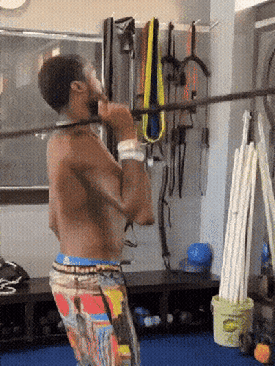 A Shirtless Man Is Doing A Pull Up In A Gym GIF