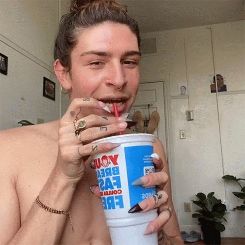 A Shirtless Man Is Drinking From A Cup That Says Eve2 GIF