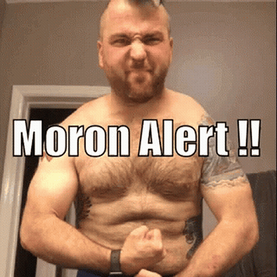 A Shirtless Man Is Flexing His Muscles With The Words Moron Alert Written On His Chest . GIF