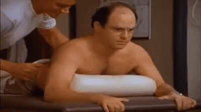 A Shirtless Man Is Getting A Massage From A Nurse While Laying On A Table . GIF