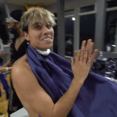 A Shirtless Man Is Getting His Hair Cut With A Purple Cloth GIF