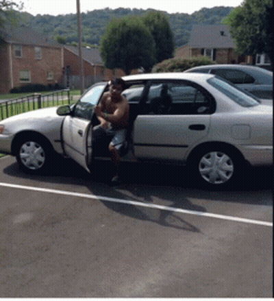 A Shirtless Man Is Getting Out Of A White Car In A Parking Lot GIF