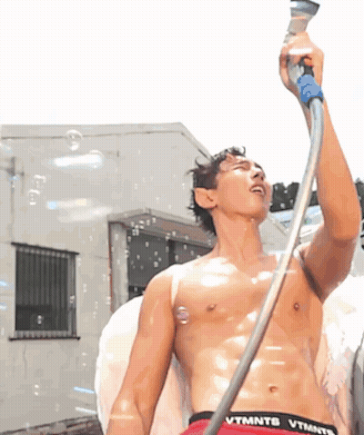 A Shirtless Man Is Holding A Hose With The Word Vtmntb On It GIF