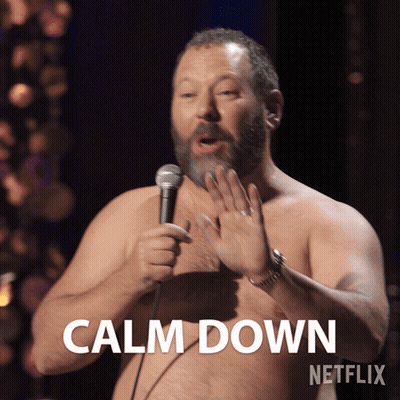 A Shirtless Man Is Holding A Microphone And Says Calm Down On The Screen GIF