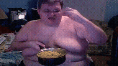 A Shirtless Man Is Holding A Pot Of Food In Front Of His Face GIF