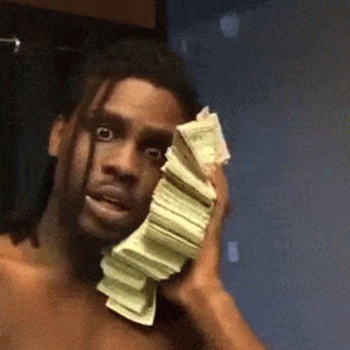 A Shirtless Man Is Holding A Stack Of Money Over His Face . GIF