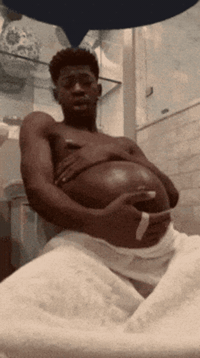 A Shirtless Man Is Holding His Pregnant Belly GIF