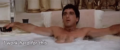 A Shirtless Man Is Laying In A Bathtub With His Arms Outstretched And Says `` I Work Hard For This '' . GIF