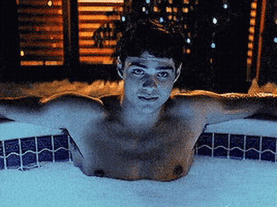 A Shirtless Man Is Laying In A Bubble Bath GIF