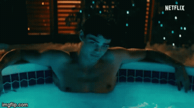A Shirtless Man Is Laying In A Hot Tub With A Netflix Logo Behind Him GIF
