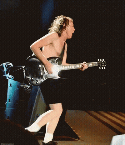 A Shirtless Man Is Playing A Guitar In Front Of A Stack Of Speakers GIF