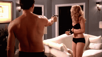 A Shirtless Man Is Pointing A Gun At A Woman In Black Underwear GIF