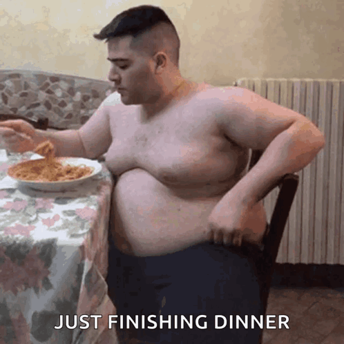 A Shirtless Man Is Sitting At A Table With A Bowl Of Spaghetti And The Words Just Finishing Dinner Below Him GIF