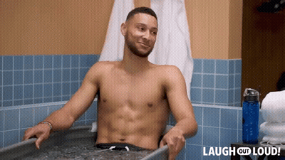 A Shirtless Man Is Sitting In A Bathtub With The Words Laugh Out Loud Behind Him GIF
