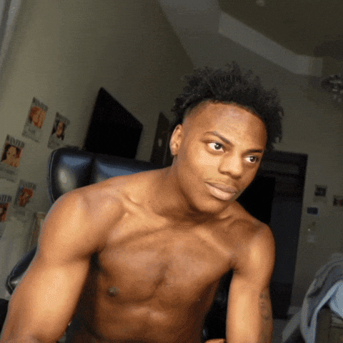 A Shirtless Man Is Sitting In A Chair In Front Of A Wall With Wanted Posters GIF