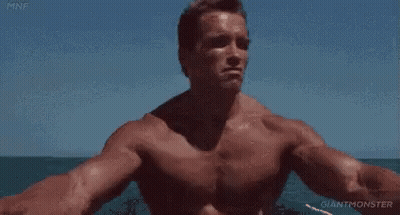 A Shirtless Man Is Sitting On A Boat In The Ocean . GIF