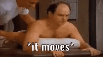 A Shirtless Man Is Sitting On A Table Getting A Massage . GIF
