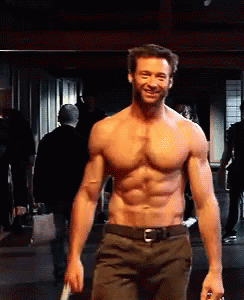 A Shirtless Man Is Smiling While Holding A Knife In His Hand GIF