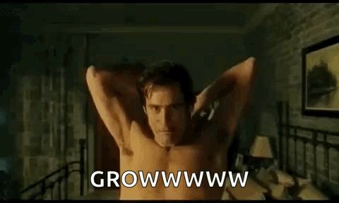 A Shirtless Man Is Standing In A Bedroom With His Arms Outstretched And Saying `` Growwww '' . GIF