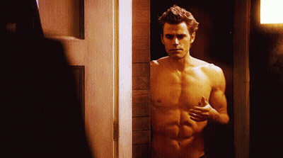 A Shirtless Man Is Standing In A Doorway With His Hands On His Chest GIF