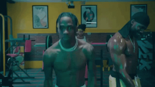 A Shirtless Man Is Standing In A Gym Next To A Woman . GIF