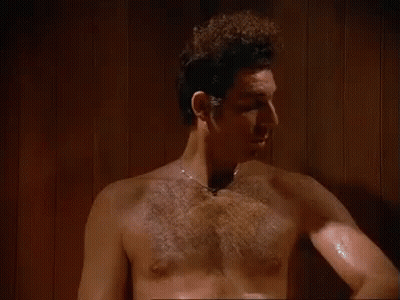 A Shirtless Man Is Standing In A Sauna With The Words `` It 'S Like A Sauna In Here '' . GIF