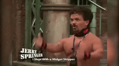A Shirtless Man Is Standing In Front Of A Building Holding A Sword . GIF