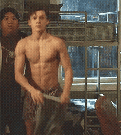 A Shirtless Man Is Standing In Front Of A Bunk Bed In A Bedroom . GIF