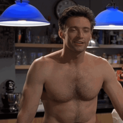 A Shirtless Man Is Standing In Front Of A Clock GIF