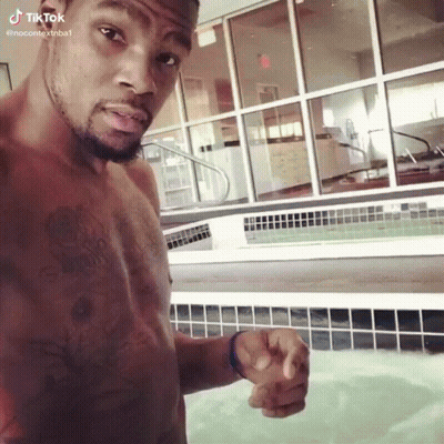 a shirtless man is standing in front of a pool and pointing