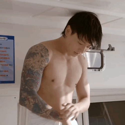 A Shirtless Man Is Standing In Front Of A Sign That Says ' Swimming Rules ' On It GIF