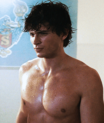 A Shirtless Man Is Standing In Front Of A Superman Sign GIF
