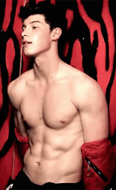 A Shirtless Man Is Standing In Front Of A Zebra Print Wall GIF