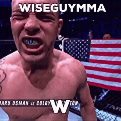 A Shirtless Man Is Standing In Front Of An American Flag With The Caption Wiseguymma GIF