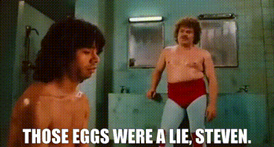 A Shirtless Man Is Standing Next To A Shirtless Wrestler In A Bathroom . GIF