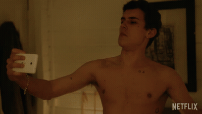 A Shirtless Man Is Taking A Selfie With A Netflix Logo In The Background GIF