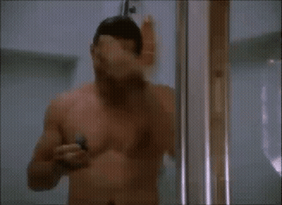 A Shirtless Man Is Taking A Shower And Using A Razor GIF