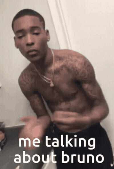 A Shirtless Man Is Talking About Bruno While Standing In Front Of A Mirror GIF