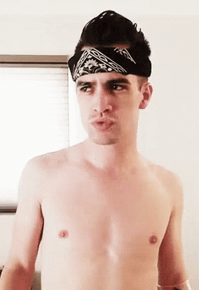 A Shirtless Man Is Wearing A Bandana On His Head . GIF